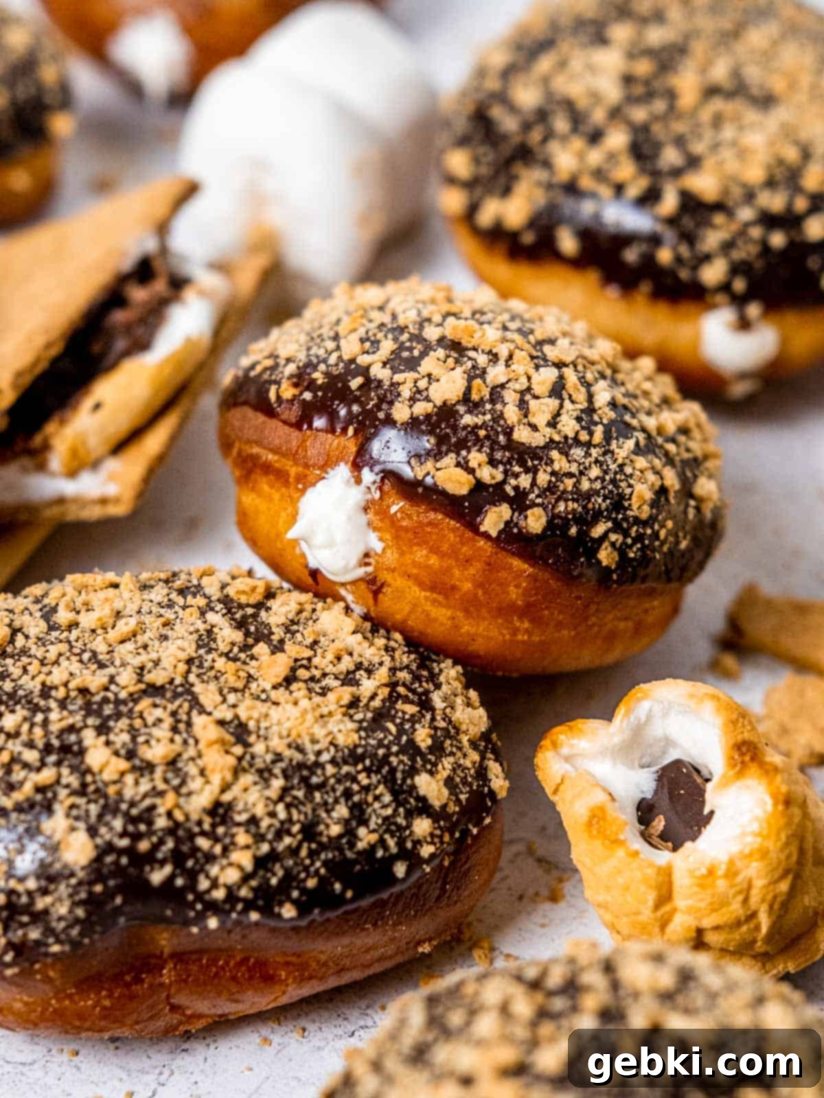 Gooey S'mores Stuffed Donuts 1 A S'mores donut filled with marshmallow cream and topped with chocolate ganache and graham cracker crumbs, showcasing its delicious layers.