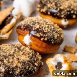 Gooey S'mores Stuffed Donuts 10 A perfectly fried and filled S'mores donut, showcasing its marshmallow cream, chocolate ganache, and graham cracker topping.