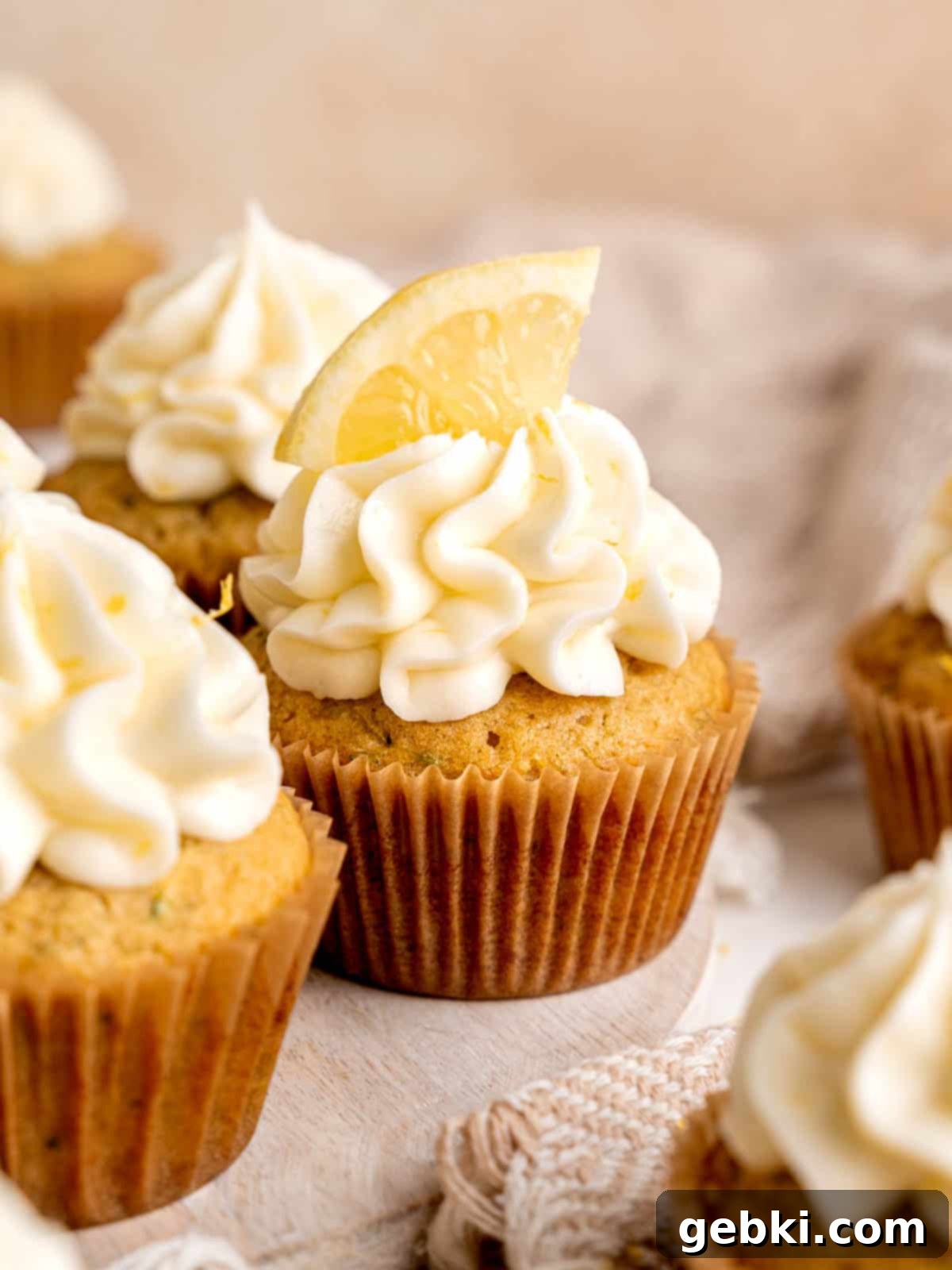 A lemon zucchini cupcake with lemon cream cheese frosting and a lemon slice on top.
