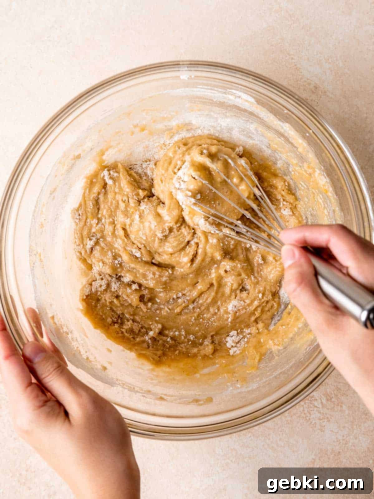 Whisking dry ingredients into wet ingredients.