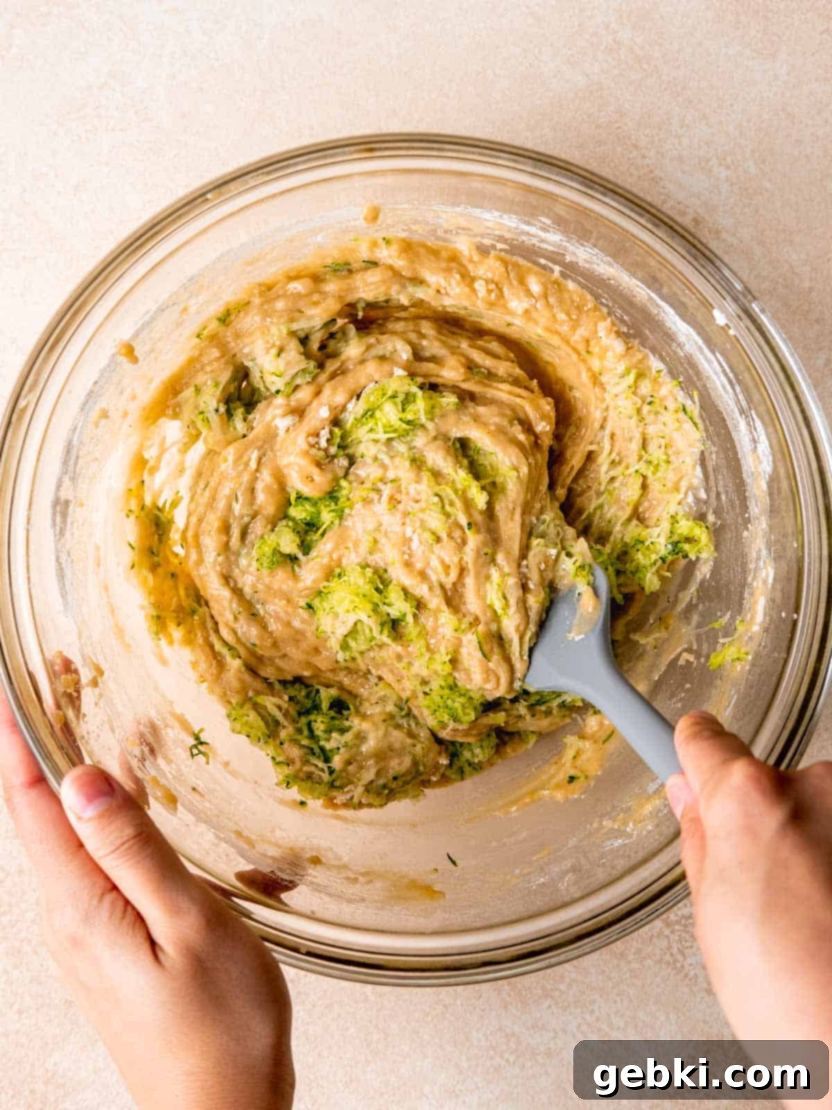 Folding grated zucchini into lemon cupcake batter.