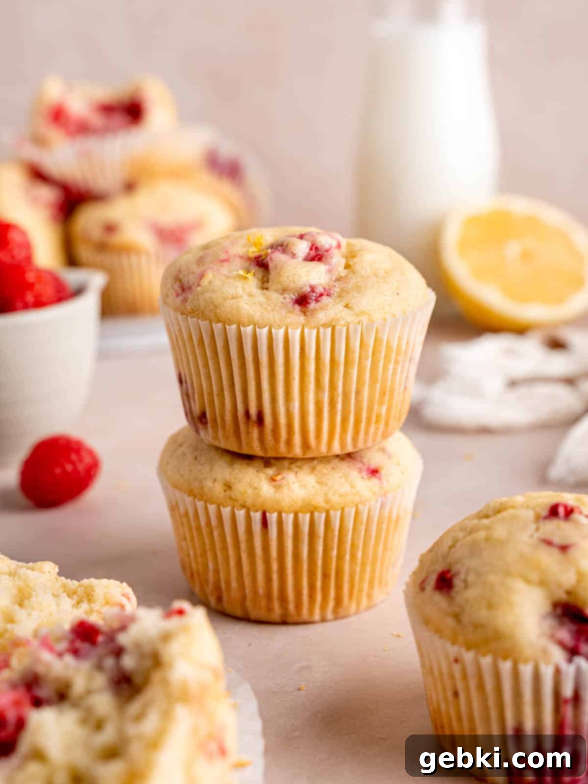 Irresistible Lemon Raspberry Muffins 1 Lemon raspberry muffins stacked on top of each other, showcasing their fluffy texture and berry-filled interior.
