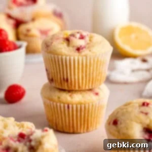 Irresistible Lemon Raspberry Muffins 11 A stack of perfectly baked lemon raspberry muffins, showcasing their golden tops and visible fruit.