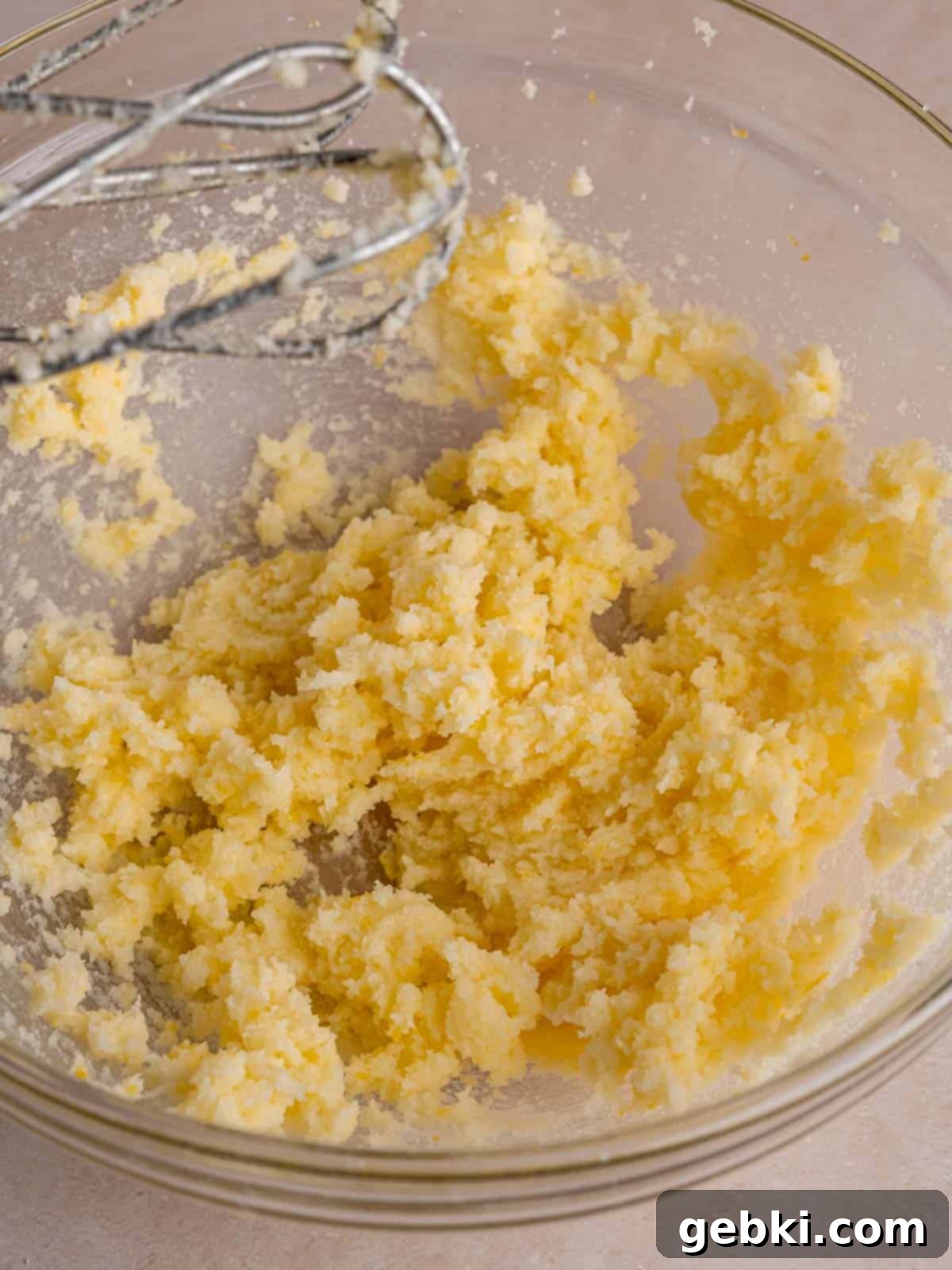 Irresistible Lemon Raspberry Muffins 4 Butter, sugar, and lemon zest being creamed together in a bowl with an electric mixer.