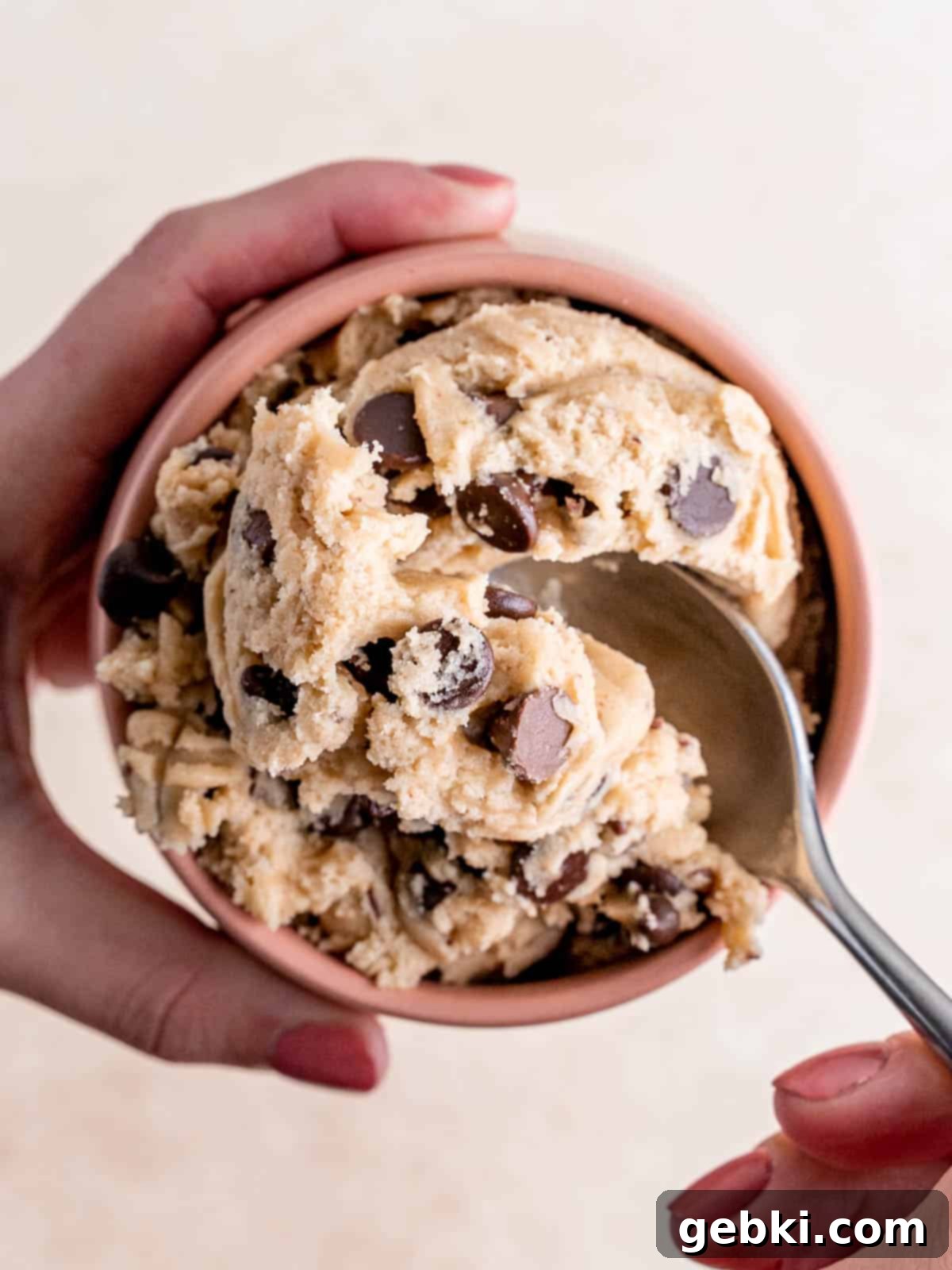 No Bake Chocolate Chip Bliss 2 Top view of a scoop of edible chocolate chip cookie dough in a cup with a spoon digging into it.