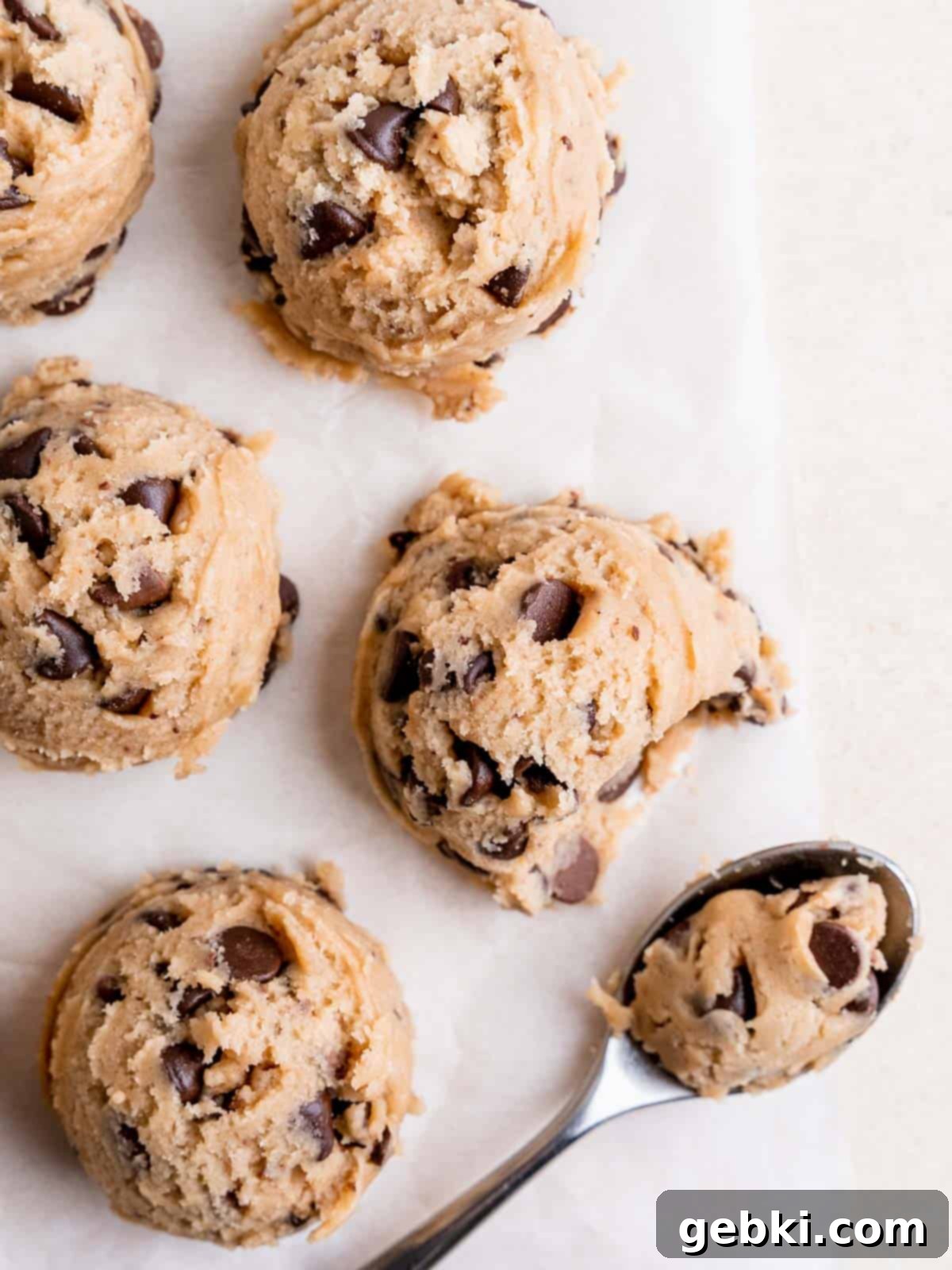No Bake Chocolate Chip Bliss 6 Top view of cookie dough scoops on a sheet of parchment paper.