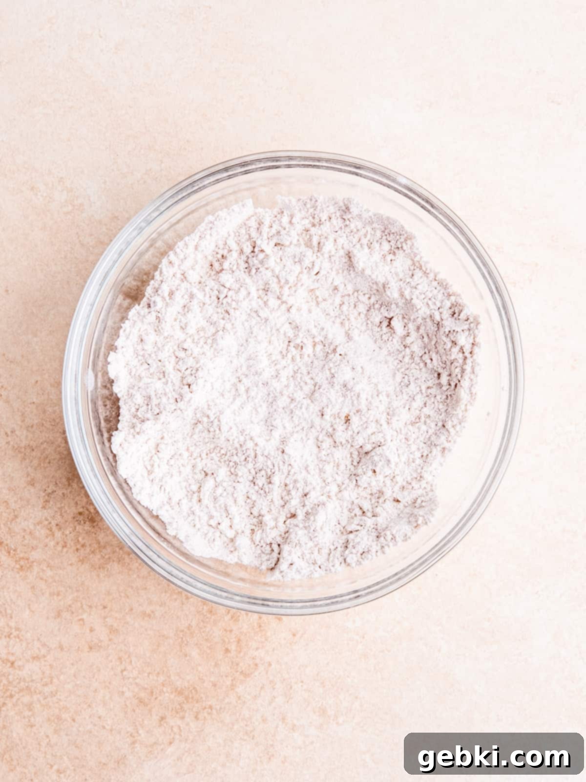 Whisking flour, baking soda, salt and pumpkin pie spice in a bowl for the pumpkin batter.