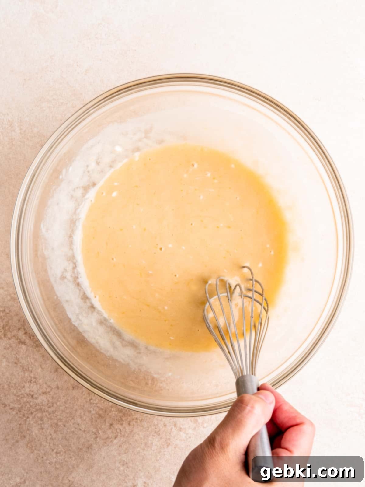Whisking oil, sugars, egg, sour cream and milk in a bowl for the chocolate batter.