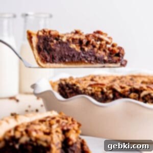 Fudgy Pecan Brownie Pie 12 Pecan Brownie Pie with a slice missing, showing the layers.