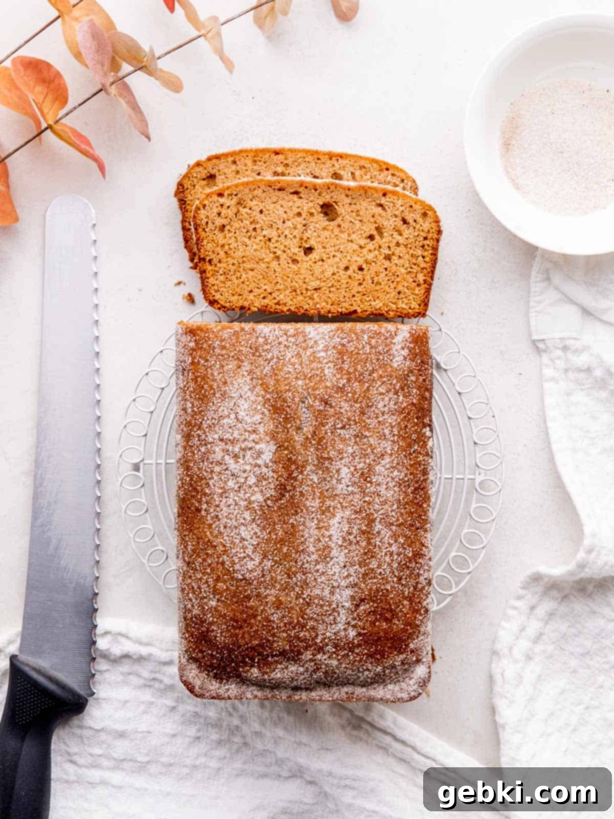 Spiced Apple Cider Loaf Cake 8 Top view of the apple cider loaf cake topped with chai sugar. Two slices are cut and laid next to the loaf, showing the moist interior.