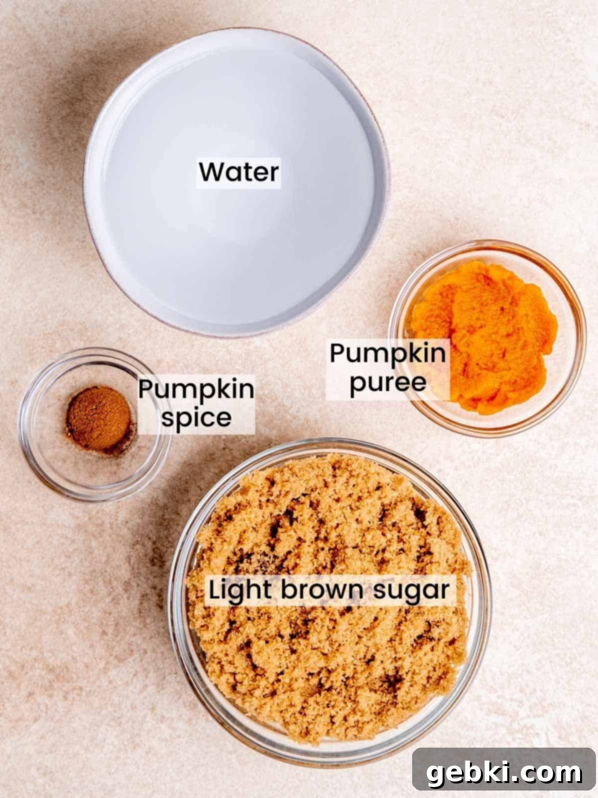A flat lay of ingredients, including pumpkin puree, pumpkin pie spice, and brown sugar, ready for homemade pumpkin spice simple syrup.