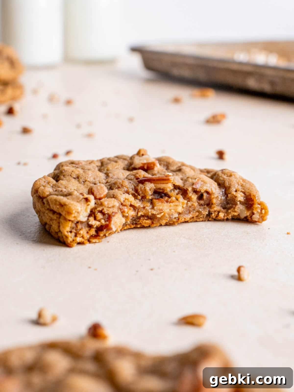 A maple pecan cookie with a bite taken out of it.