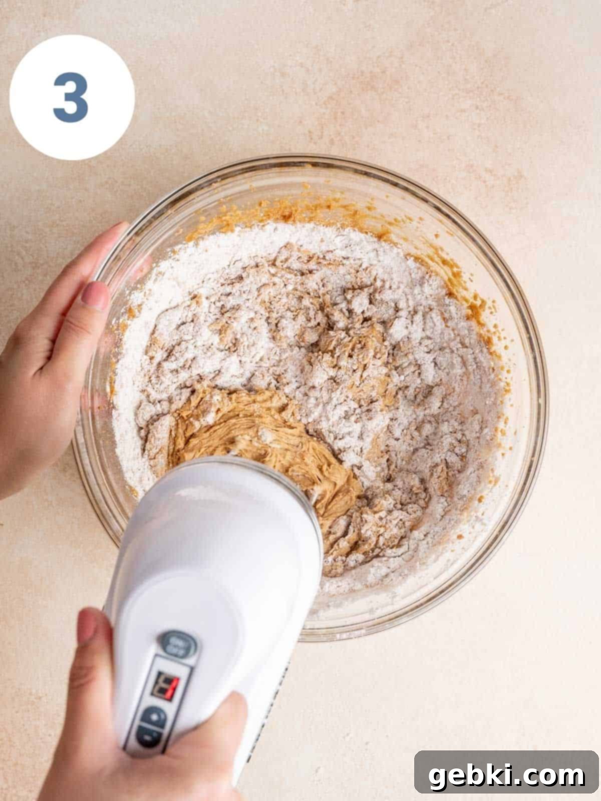 Mixing dry ingredients into wet ingredients.