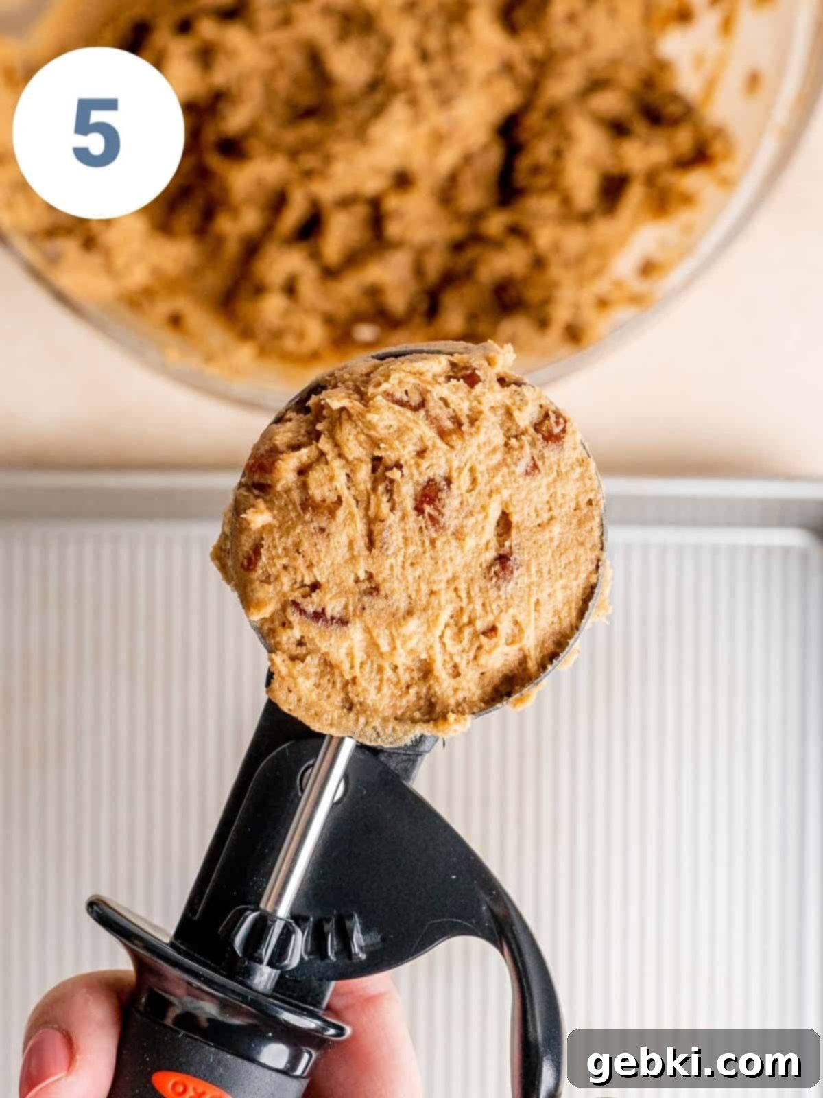 A large cookie scoop with maple pecan dough.