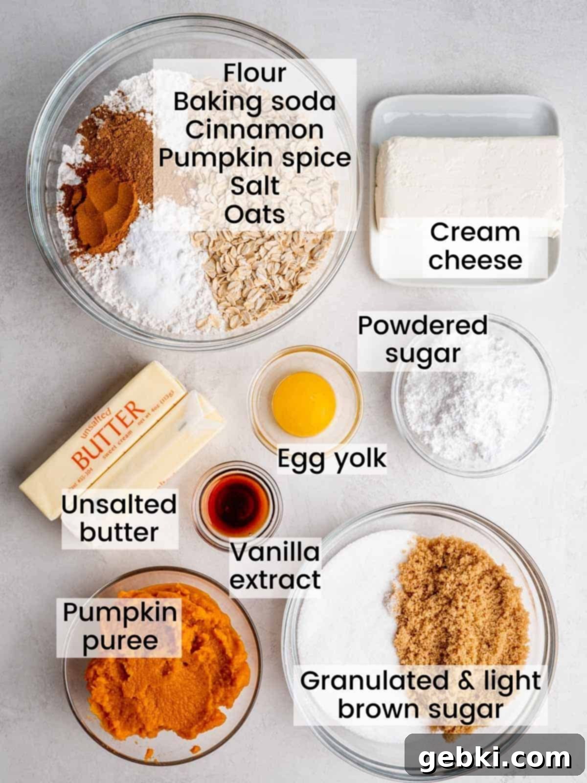 Creamy Pumpkin Cheesecake Oatmeal Cookies 3 A visual guide showing all the individual ingredients for oatmeal pumpkin cheesecake cookies laid out and clearly labeled on a wooden surface.