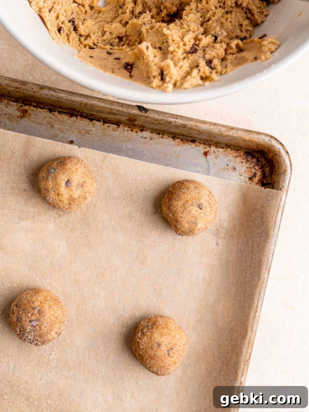 Nutty Browned Butter Snickerdoodle Cookies 8 Snickerdoodle cookie dough balls on a baking sheet.