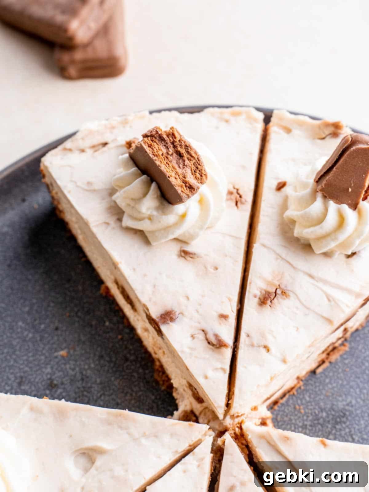 Tim Tam Cheesecake 2 top view of Tim Tam Cheesecake sliced into triangles and decorated with whipped cream and Tim Tams