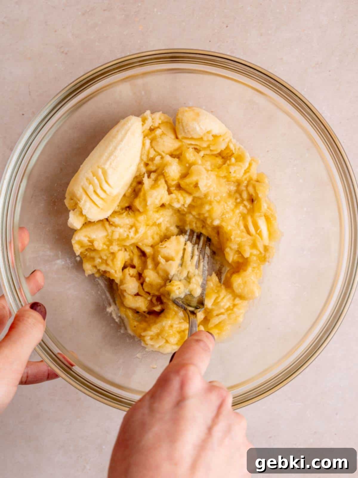 Effortless One-Bowl Banana Bread 4 Mashing overripe bananas in a bowl with a fork.