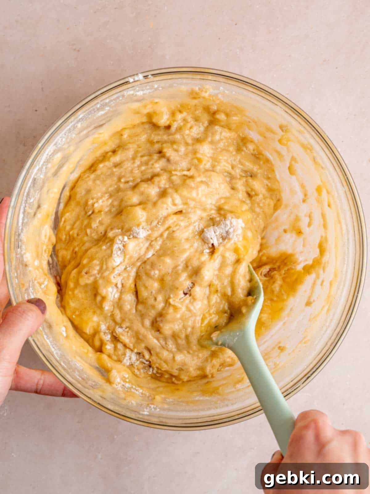 Effortless One-Bowl Banana Bread 6 Folding flour, baking soda, cinnamon, and salt into a bowl of wet banana bread ingredients.