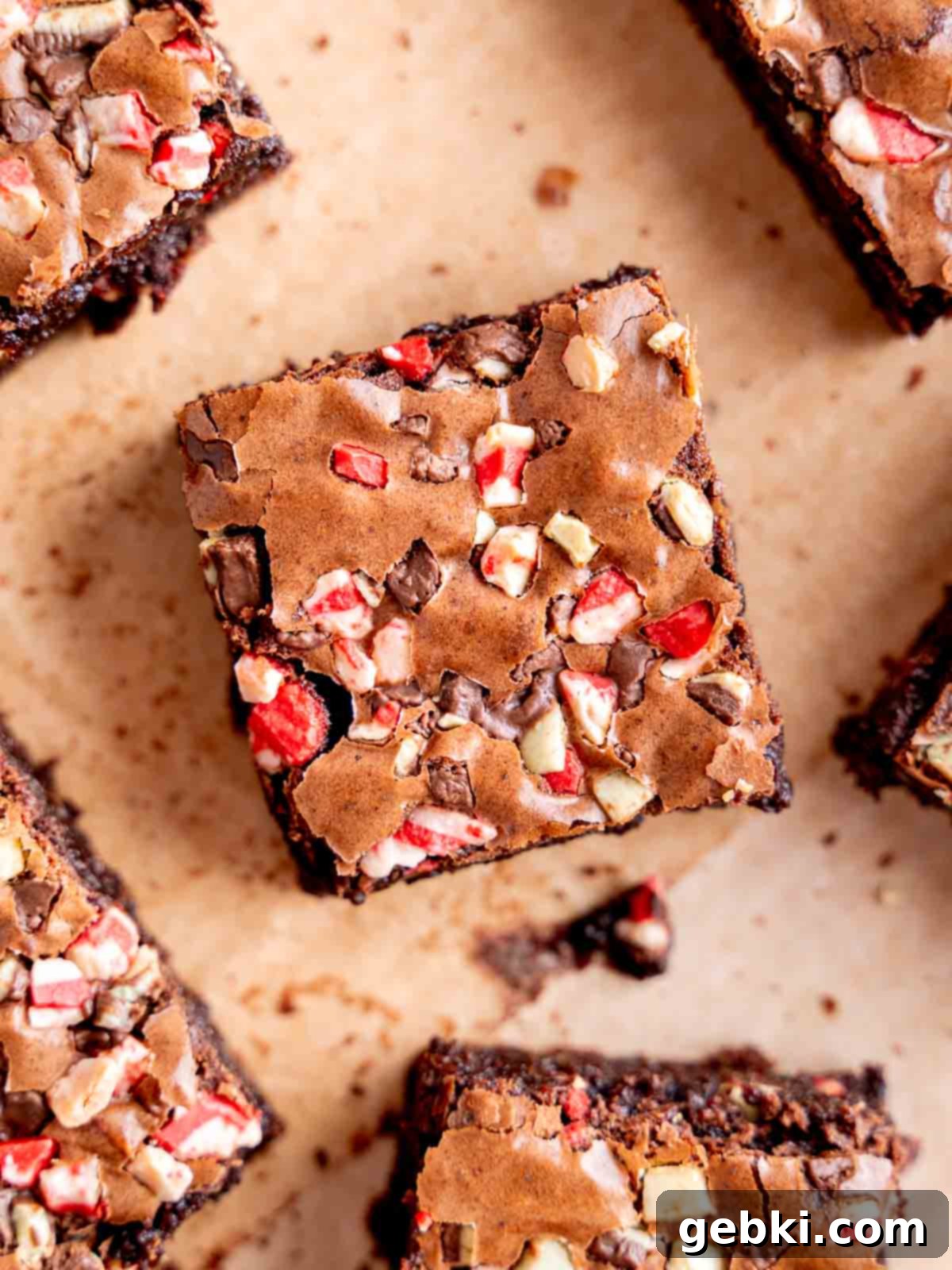 Top view of a freshly baked brownie, perfectly cut, adorned with both regular and peppermint Andes mint bits, highlighting its appealing texture and rich color.