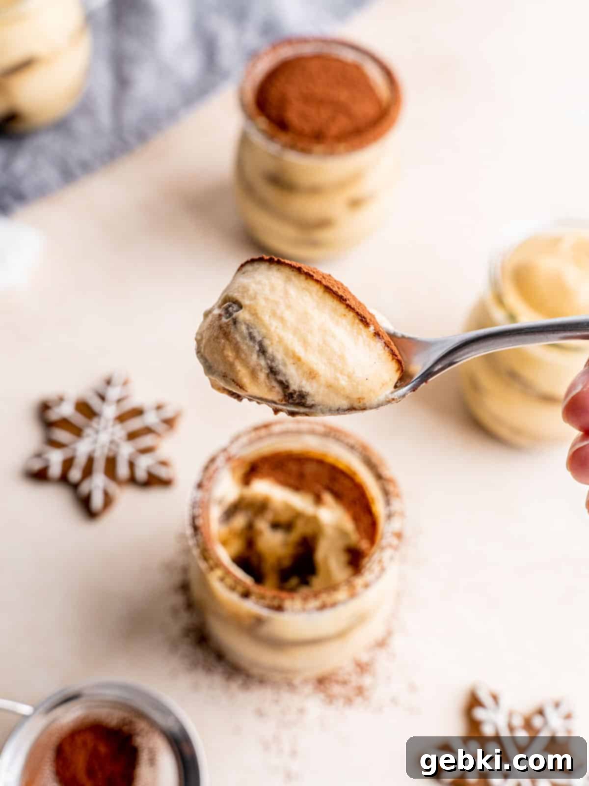 A spoonful of creamy gingerbread tiramisu with coffee-soaked cookie and cocoa.