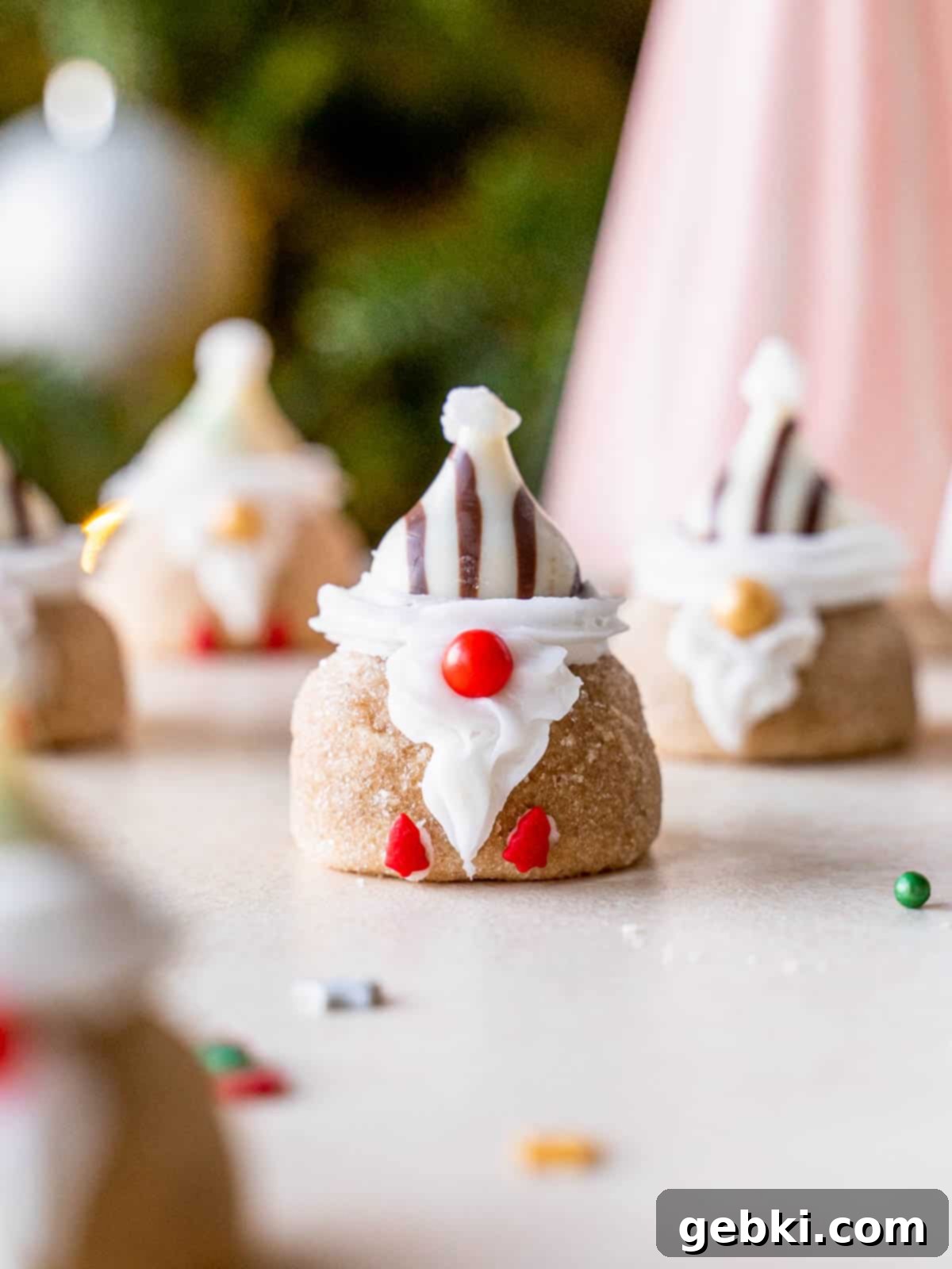 A cute Christmas gnome cookie with a chocolate Santa hat and sprinkle nose and feet.
