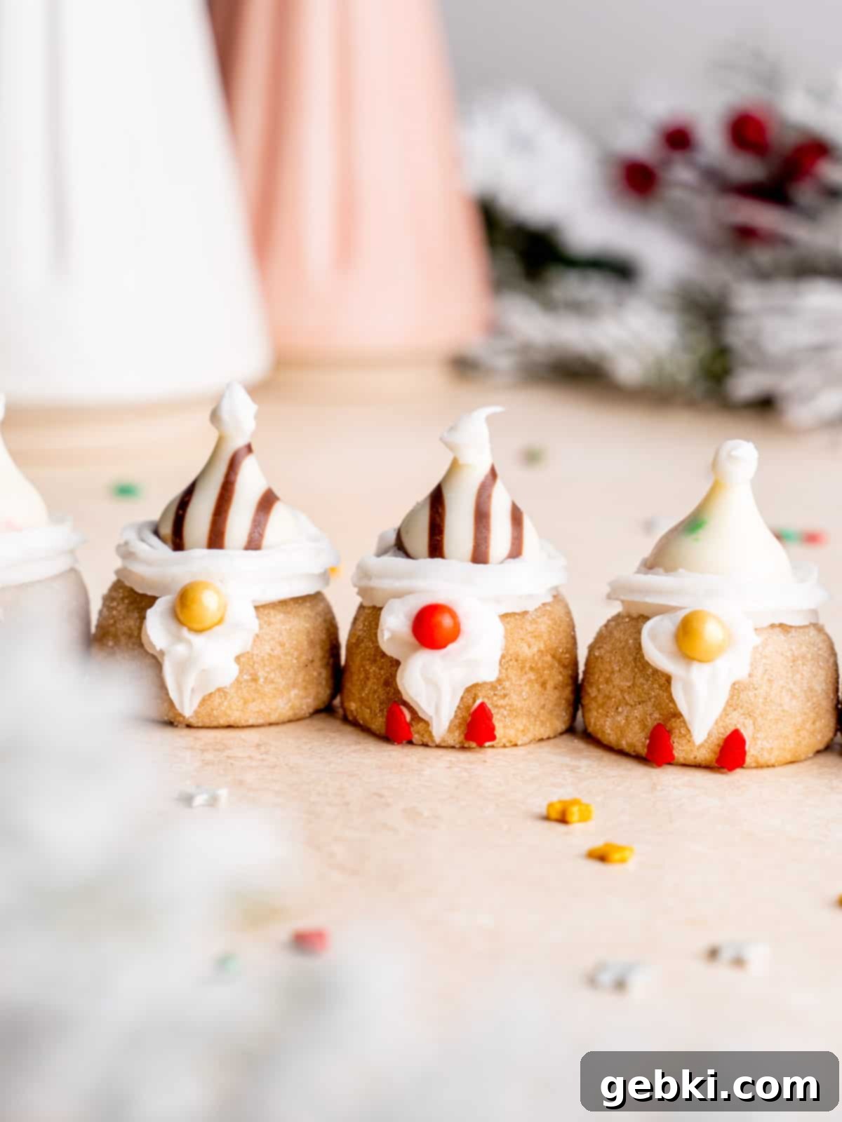 The cutest gnome cookies lined up in a Christmasy setting, ready for the holidays.