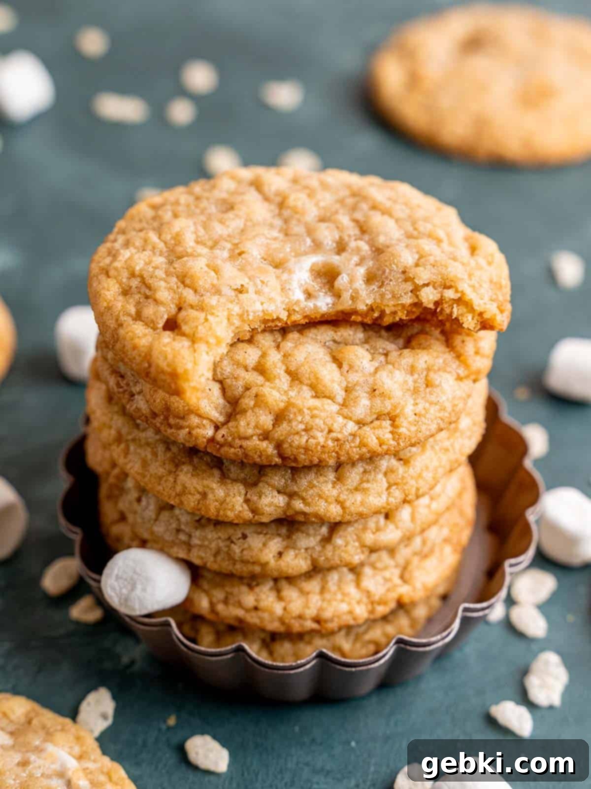 Toasted Marshmallow Crunch Cookies 10 Marshmallow crispy cookies stacked with a bite taken out of one.
