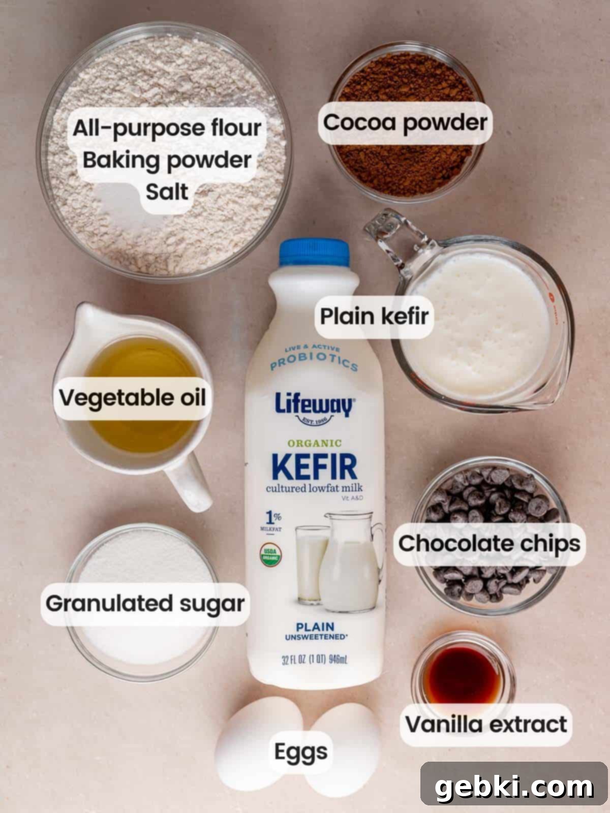 Decadent Double Chocolate Loaf 3 A flat lay photograph showcasing all the dry and wet ingredients neatly arranged on a kitchen counter, ready to be used for making the chocolate loaf cake.
