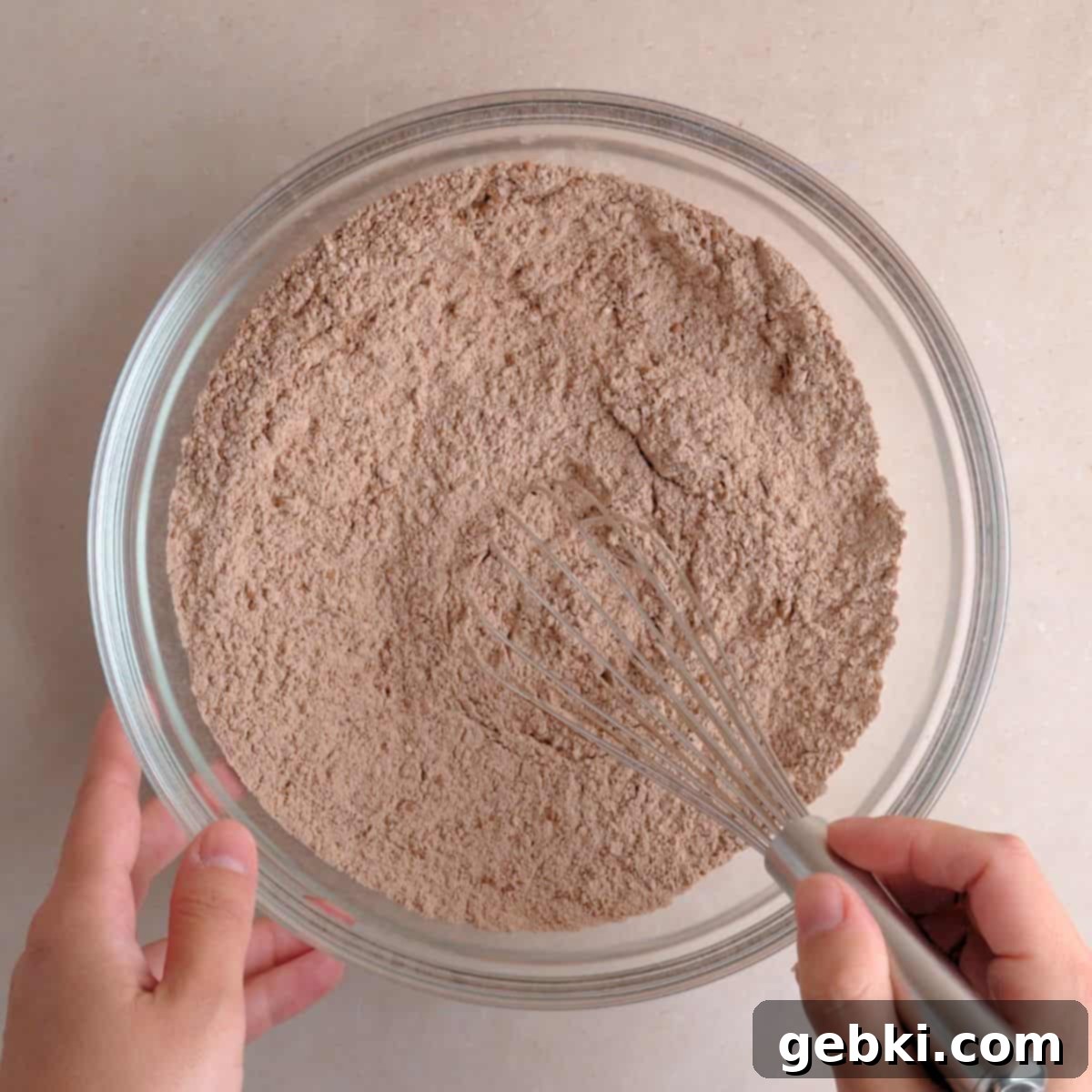 Decadent Double Chocolate Loaf 4 A large mixing bowl containing flour, granulated sugar, dark cocoa powder, baking powder, and salt, being whisked thoroughly to combine the dry ingredients.