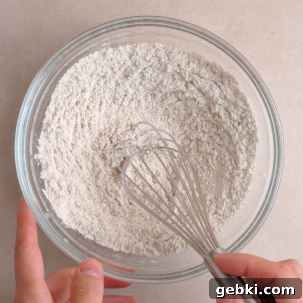 Effortless Sourdough Snickerdoodles 4 Flour, cinnamon, baking soda, and salt whisked together in a bowl, preparing the dry ingredients for snickerdoodle cookies.