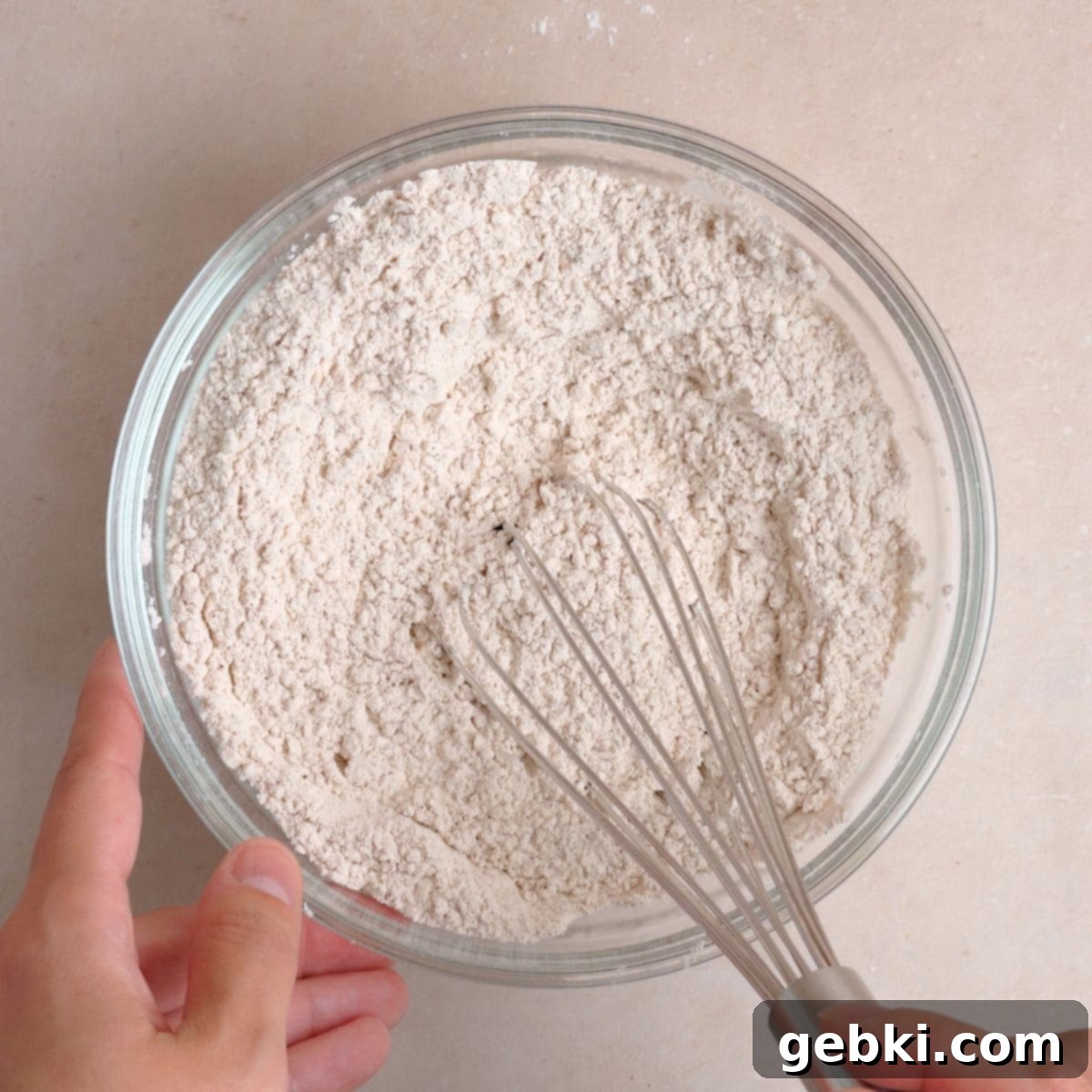 Effortless Pumpkin Oatmeal Muffins with Perfect Crumbly Streusel 5 A medium bowl showing dry ingredients including flour, baking powder, pumpkin pie spice, cinnamon, and salt, whisked together until well combined.