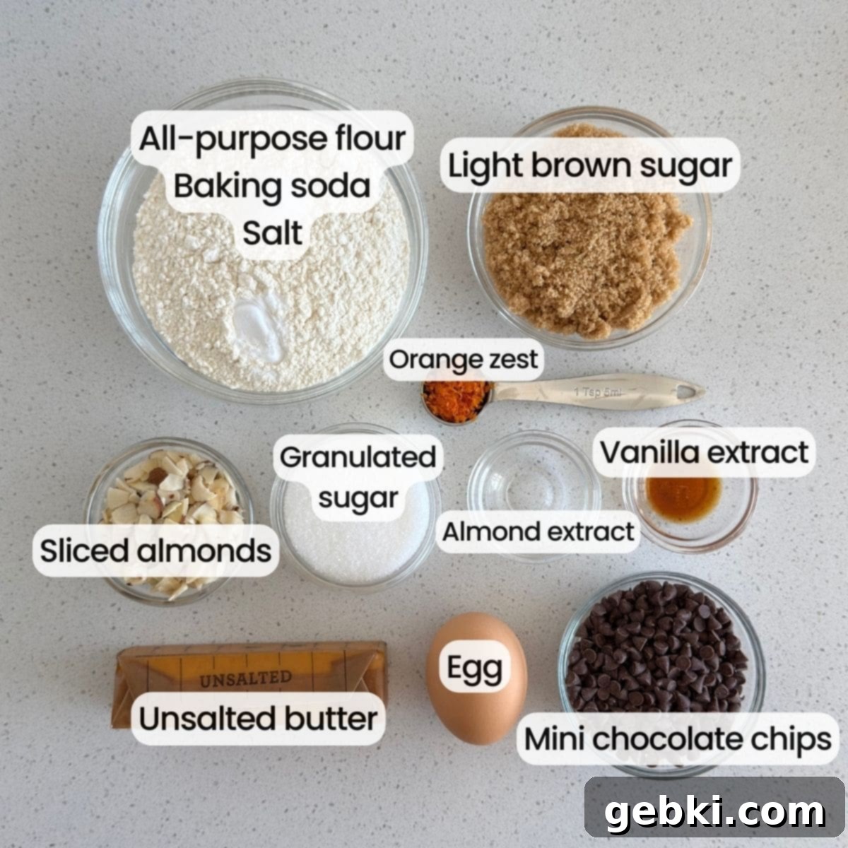 Orange Almond Chocolate Chunk Cookies 3 A photo showcasing all the ingredients needed to make orange almond chocolate chip cookies, laid out on a countertop.