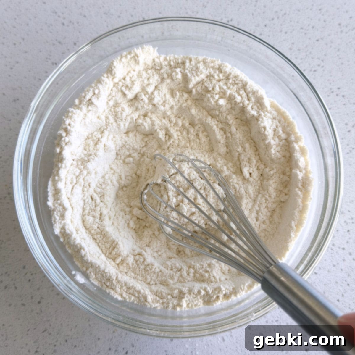 Flour, baking soda, and salt mixed together in a bowl, ready to be added to the wet ingredients.