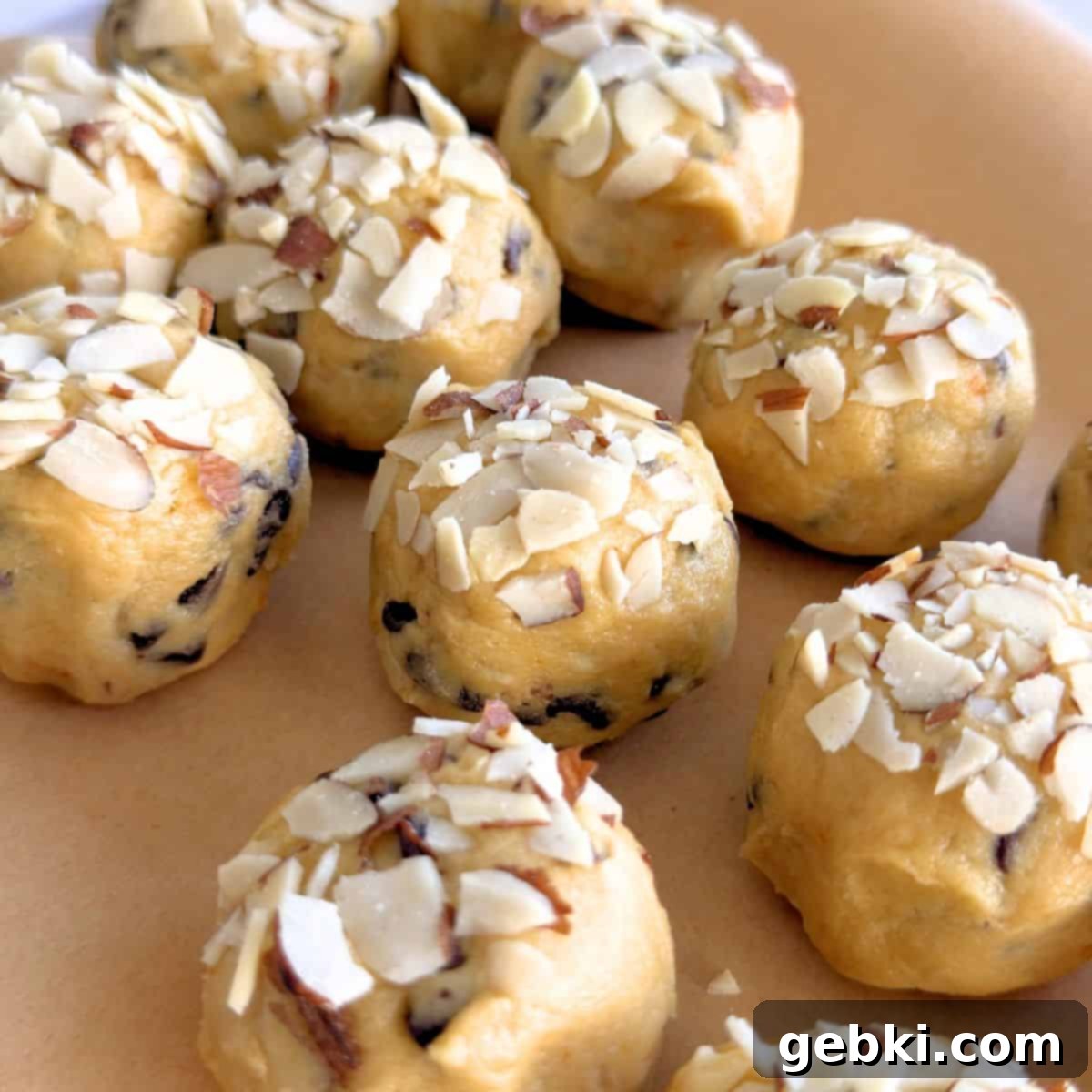 Cookie dough balls topped with extra sliced almonds for added crunch and visual appeal.